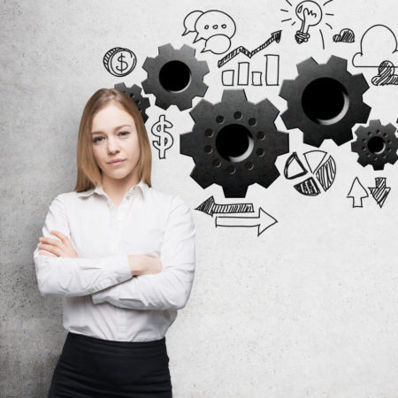 A young business woman with crossed hands. Gears are drawn on the concrete wall. A concept of the business optimisation process. How To Optimize Your LinkedIn Profile